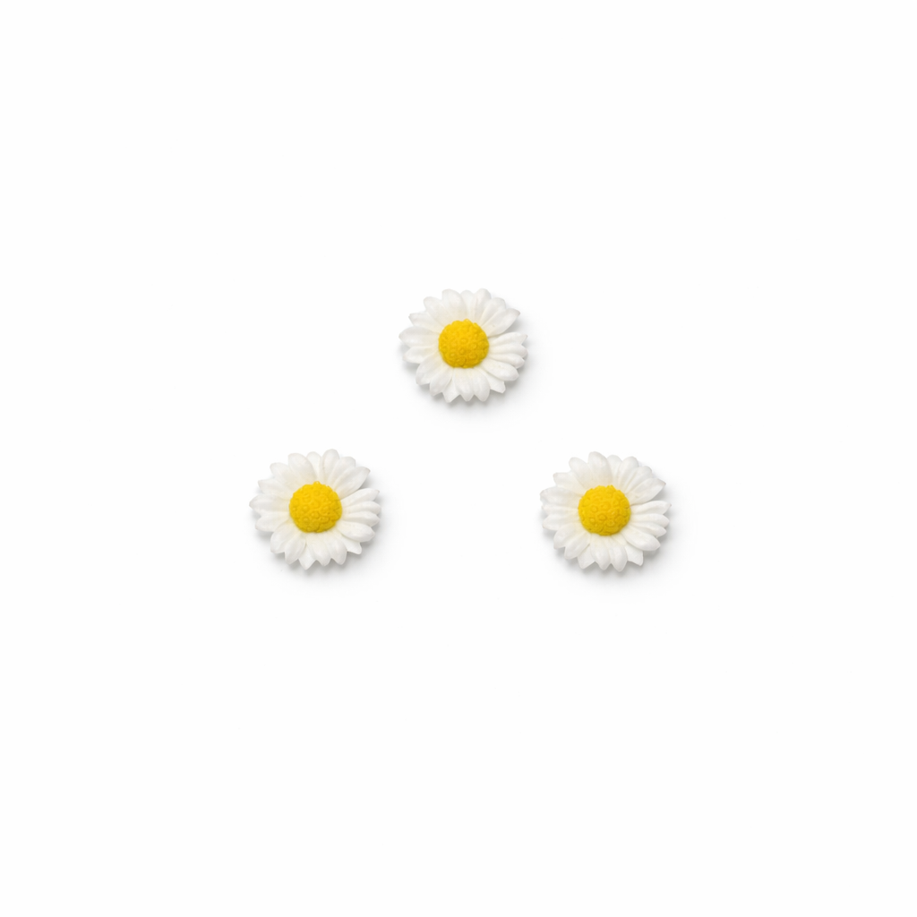 Three daisy-shaped nail charms on a white background