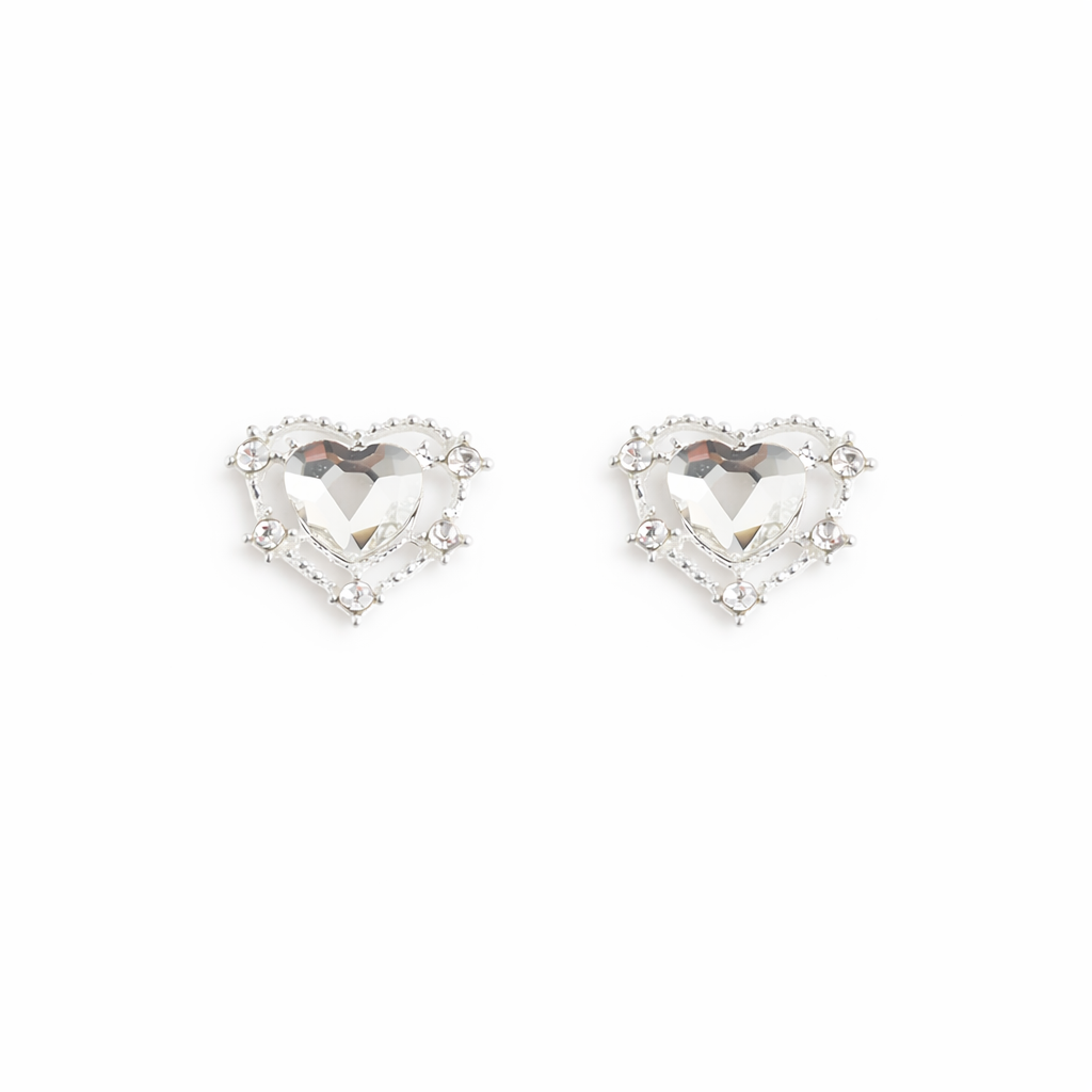 Silver heart-shaped nail charms with clear gemstones on a white background